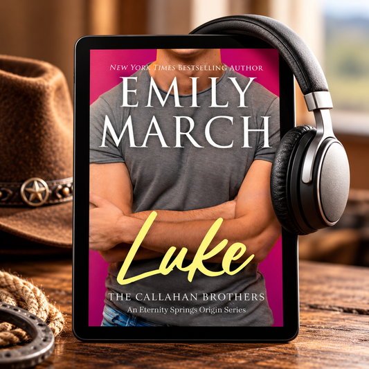 A tablet displaying a book cover for "Luke" by Emily March, styled on a wooden table with a cowboy hat, rope, and headphones. The book cover features a man with arms crossed against a pink and gray background, with the title "Luke" in yellow script.